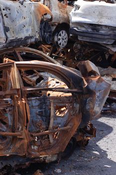 rusty burnt cars in Irpen, after being shot by Russian military and missile. Russia's invasion. war against Ukraine. Cemetery of destroyed cars of civilians who tried to evacuate from war zone.