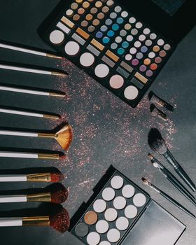 makeup brushes and eye shadow on black background.photo with copy space