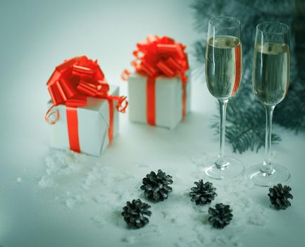 two glasses with champagne and Christmas gifts at the Christmas background .photo with copy space.