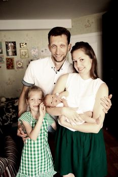 dad,daughter and mom with a newborn baby in the room for children