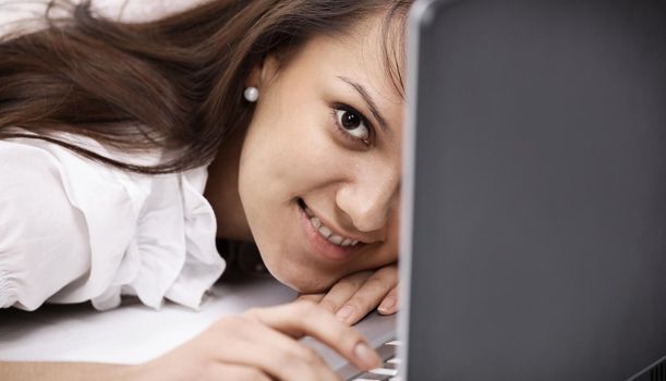 closeup. smiling young woman with laptop in the workplace.isolated on white.