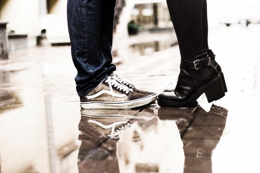 concept of love.close up of legs couple in love, reflected on wet pavement