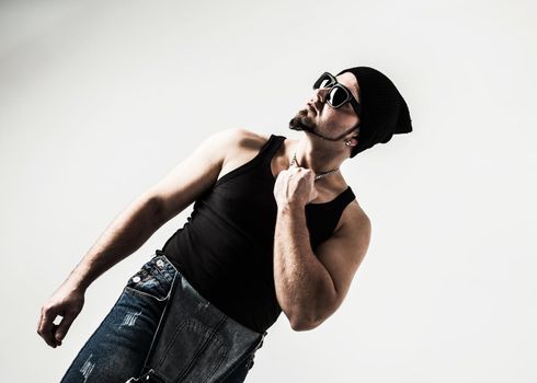 DJ rapper shirtless, with headphones and a stylish haircut on a light background . the photo has a empty space for your text