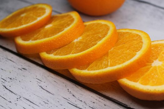 Slices of orange stacked on top of each other on a wooden table..