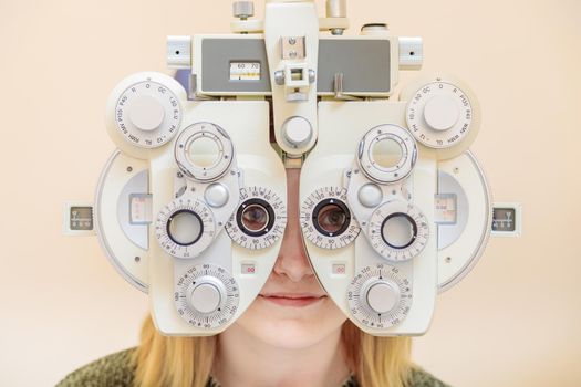 A male ophthalmologist checks a girl's eyesight using a phoropter. Vision treatment.