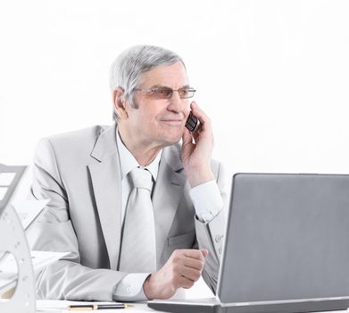 successful, experienced businessman with mobile phone sitting at his Desk .isolated on white