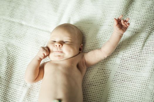 cute smiling baby lying on white blanket. the photo has a empty space for your text
