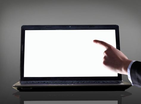 Close-up of male hand with forefinger pointing at laptop screen over black background