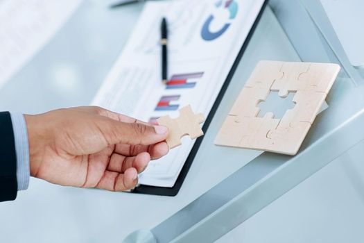 closeup. the businessman is a puzzle,sitting behind a Desk.business concept