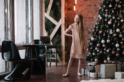 cute girl standing in a decorated living room . the concept of Christmas