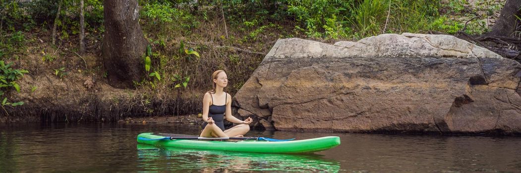 Sporty woman in yoga position on paddleboard, doing yoga on sup board, exercise for flexibility and stretching of muscles. BANNER, LONG FORMAT