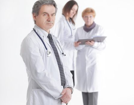 serious therapist doctor on blurred background of colleagues.