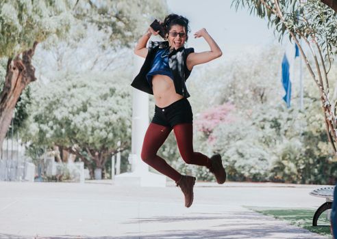 Happy urban girl jumping and listening to music, Girl jumping in the street and listening to music, Lifestyle girl listening to music, Woman jumping and enjoying music