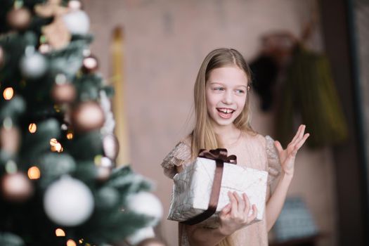 happy girl looking at her Christmas present . holiday concept