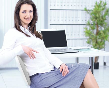 smiling employee sitting at a Desk in the office.photo with copy space