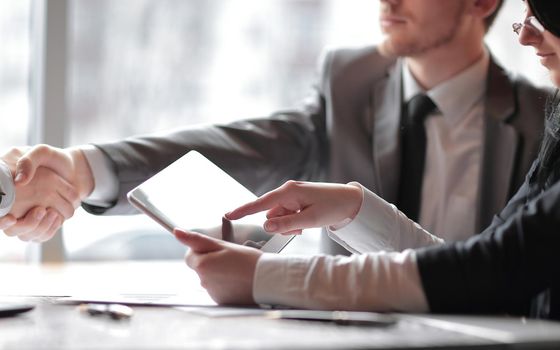 close up.the businessman uses a digital tablet at a business meeting