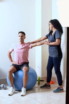 Professional physiotherapist working with female patient in rehabilitation center