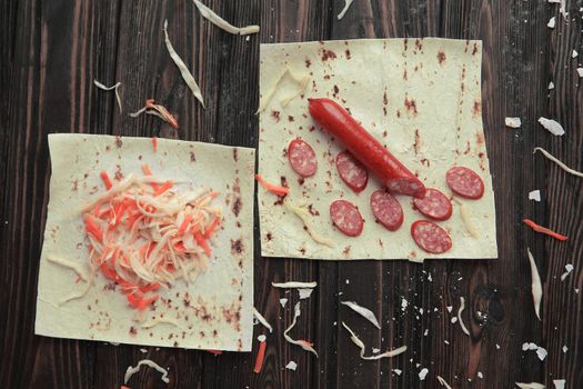 ingredients for cooking burrito on a wooden table.