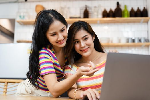 lgbtq, lgbt concept, homosexuality, portrait of two asian women posing happy together and loving each other while playing computer laptop.