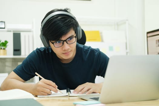 Young male student study at home. He using laptop and learning online.
