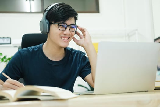 Young male student study at home. He using laptop and learning online.
