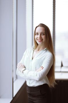 young business woman standing near the window in the corridor of the office.