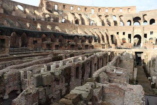 ROME, ITALY - February 05, 2022: Panoramic view around the Colosseum in city of Rome, Italy. Cold and gray sky in the background. Macro photography of the green parks with the old buildings.