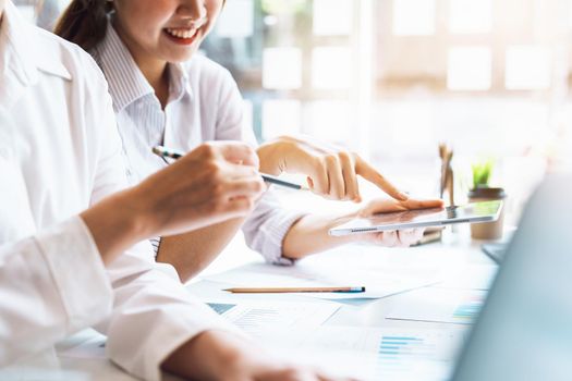 Negotiation, Analysis, Discussion, Asian woman economist and marketer using tablet computer to plan investments and financial to prevent risks and losses for the company.