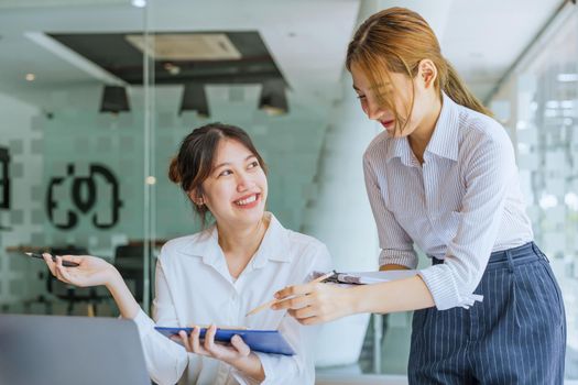 Negotiation, Analysis, Discussion: Portrait of an Asian woman economist and marketer pointing to a financial data sheet to plan investments to prevent risks and losses for the company.