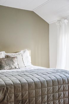 Double large bed with white and grey pillows,blankets