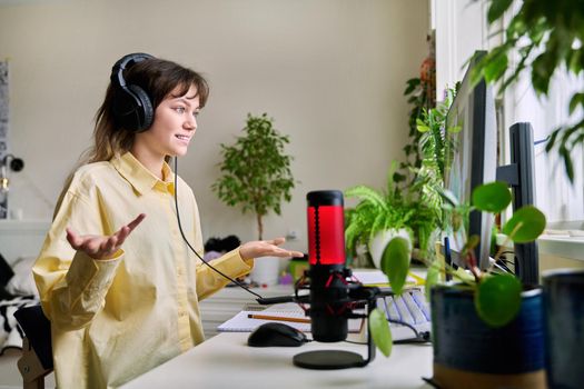 Teenage female student studying online at home, female in headphones with notebook talking to teacher by video, using computer. Chat call conference, e-learning college high school, technology concept