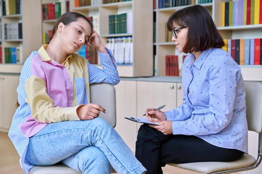 Psychologist, teacher, behavior, high school counselor counseling teenage student in library, office. Psychological help, social work, mental health, adolescence, youth psychotherapy psychology concept
