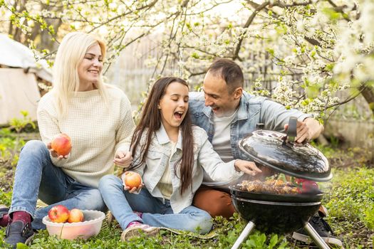 smiling parent grilling meat with daughter on camping.