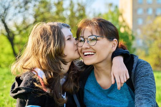 Happy mother and preteen daughter together, girl hugging and kissing mom. Family, happiness, leisure, lifestyle, relationship love, mother's day, motherhood concept