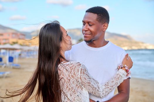 Beautiful young couple in love on beach. Portrait of Asian woman and African American man embracing. Multicultural, multiethnic family, relationships, togetherness, lifestyle, sea nature vacation