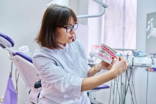 Doctor dentist consulting online looking at webcam showing dental jaw with teeth. Doctor making video call chat conference, in dental office. Medicine, telemedicine, technology, health care concept