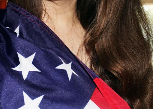 A girl with long dark hair holds a US flag in her hands. High quality photo