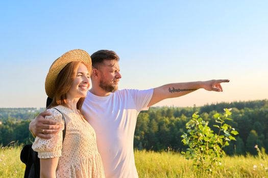 Happy middle age couple looking in distance at horizon, summer nature wild meadow background. Smiling man and woman together. People 40s, family, relationships, leisure, holidays, lifestyle concept