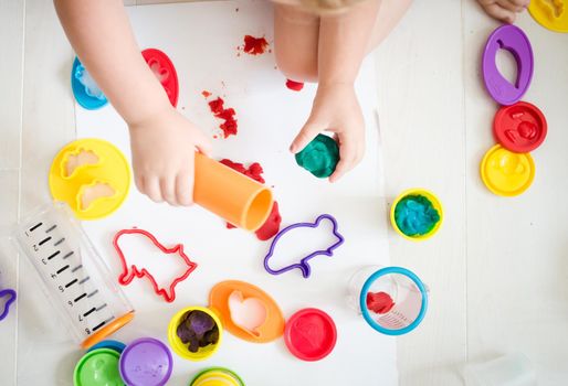 kid is playing with colourful plasticine in kindergarten. High quality photo