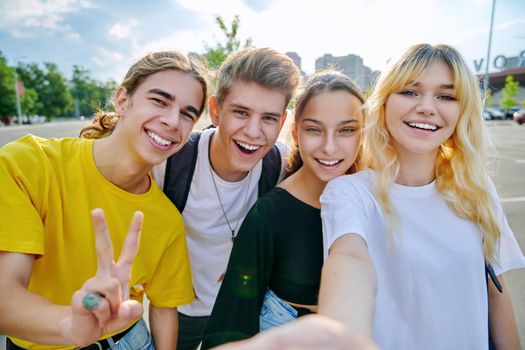 Group of happy teenage friends taking selfie photo. Best friends having fun together outdoor looking at camera. Youth, friendship, teens, adolescence, fun, joy concept