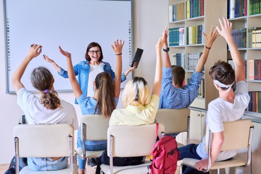 Lesson in classroom with digital screen for group of teenagers. Teaching, discussion with teenage students. Technology, education, knowledge, high school, college, youth concept