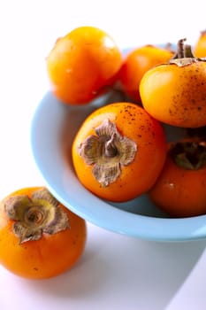 persimmons in a basket and scattered on the table. rustic style. High quality photo