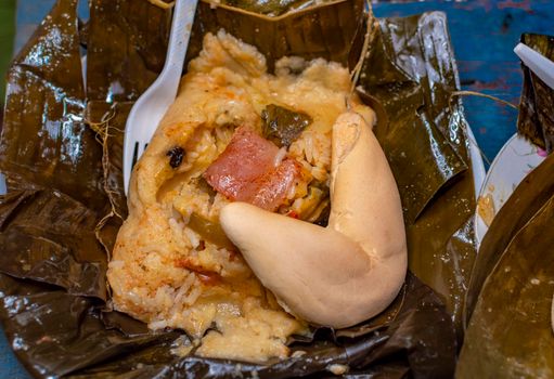 Nacatamal served in banana leaf, Close up of Nicaraguan nacatamal, Typical Nicaraguan food El nacatamal, Typical Nicaraguan food