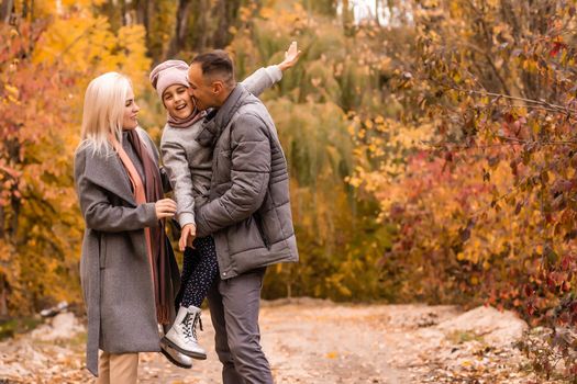 Happy family playing in autumn park.