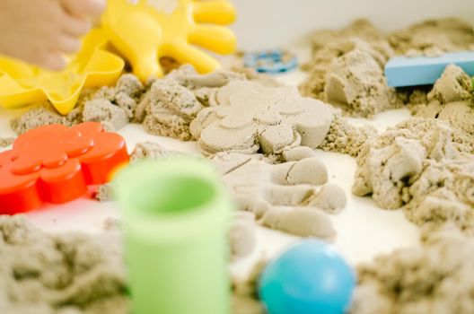 kid is playing with kinetic sand in kindergarten. High quality photo
