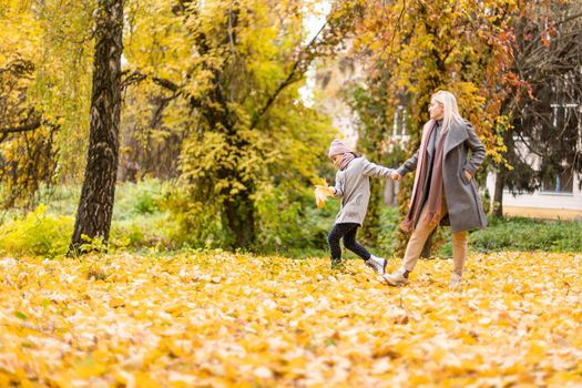 Mother and daughter in autumn yellow park