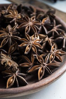 selected star anise stars on a wooden bowl. High quality photo