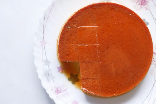 Caramel custard pudding on a plate on table ,