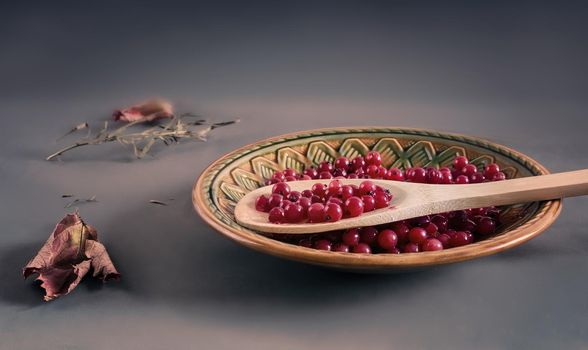 On the table in a ceramic plate juicy red currant berries