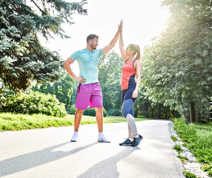 Portrait of a young couple exercising in a park outdoors